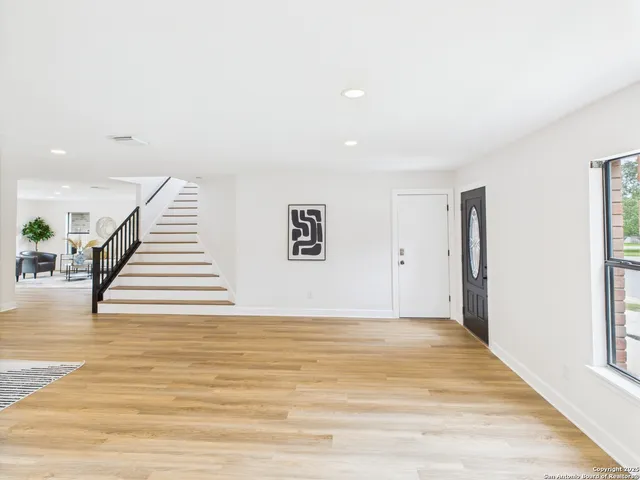 a view of a livingroom with wooden floor and stairs