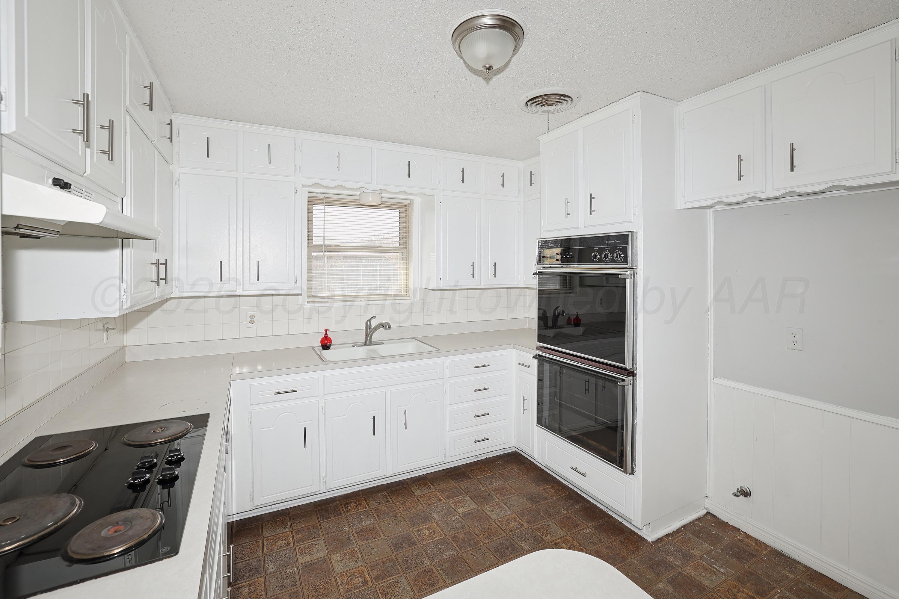 6108 Cornell Street Amarillo, TX 79109 - Photo 11 of 26 a kitchen with stainless steel appliances white cabinets and a refrigerator