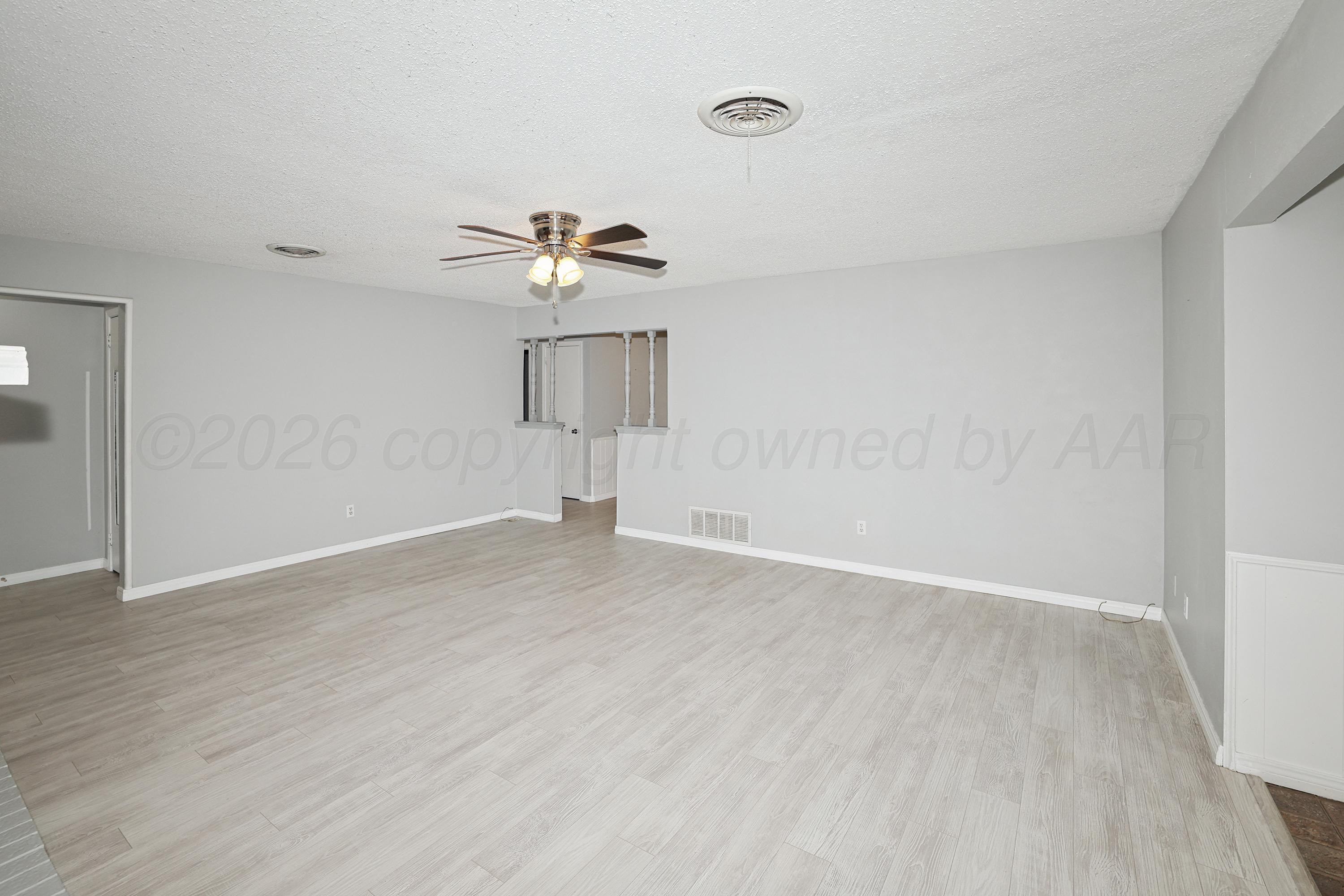 6108 Cornell Street Amarillo, TX 79109 - Photo 5 of 26 wooden floor in an empty room with a window