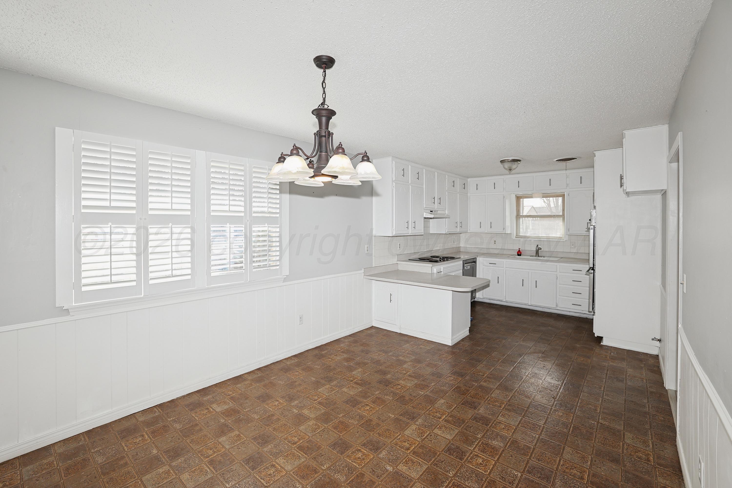 6108 Cornell Street Amarillo, TX 79109 - Photo 9 of 26 a kitchen that has a lot of white cabinets and stainless steel appliances