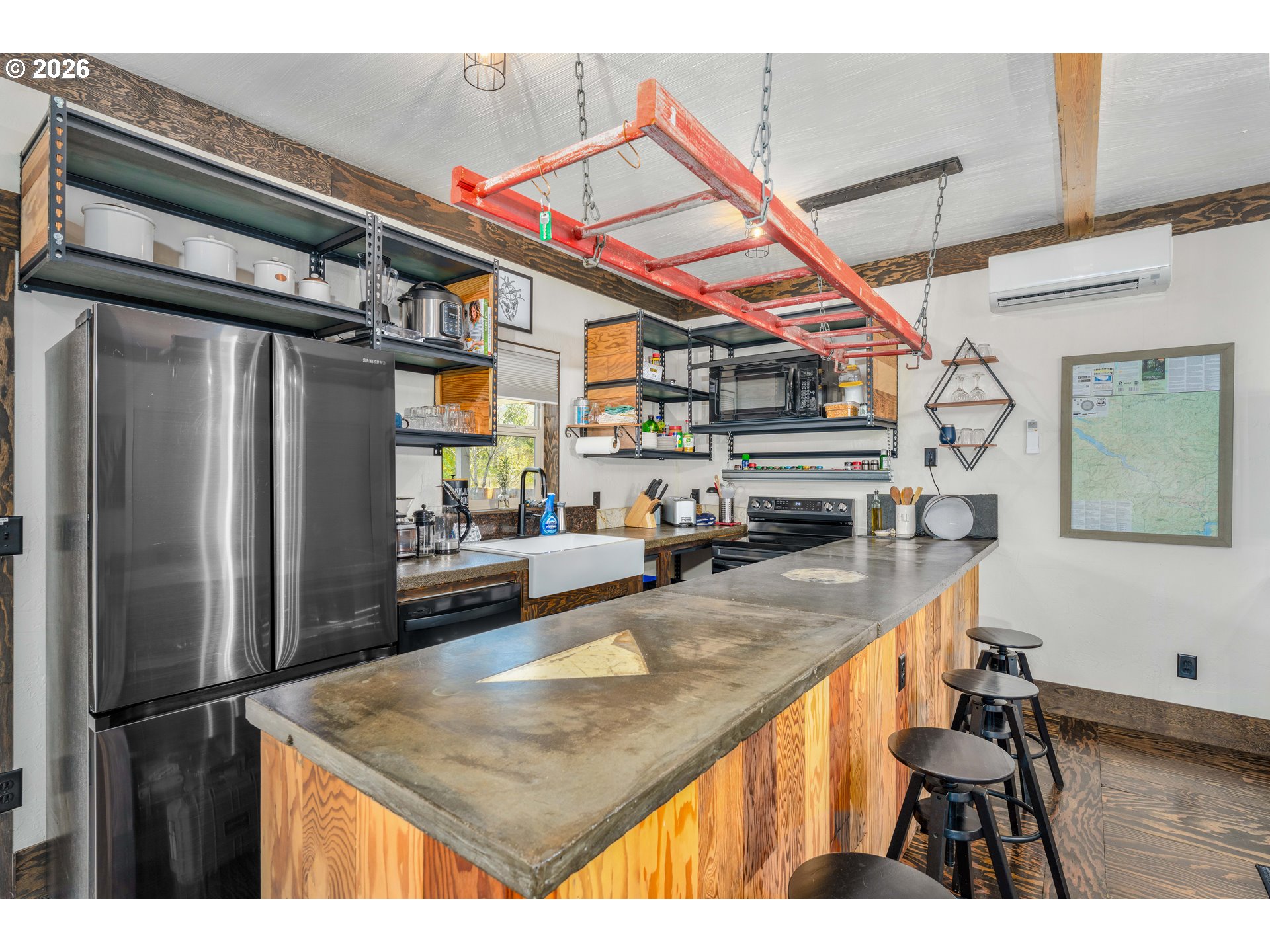 48367 Roaring Rapids Way Oakridge, OR 97463 - Photo 6 of 23 a kitchen with stainless steel appliances kitchen island a refrigerator and a wooden floor