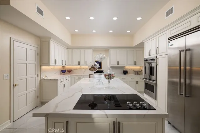 a kitchen with stainless steel appliances kitchen island granite countertop a refrigerator and a sink