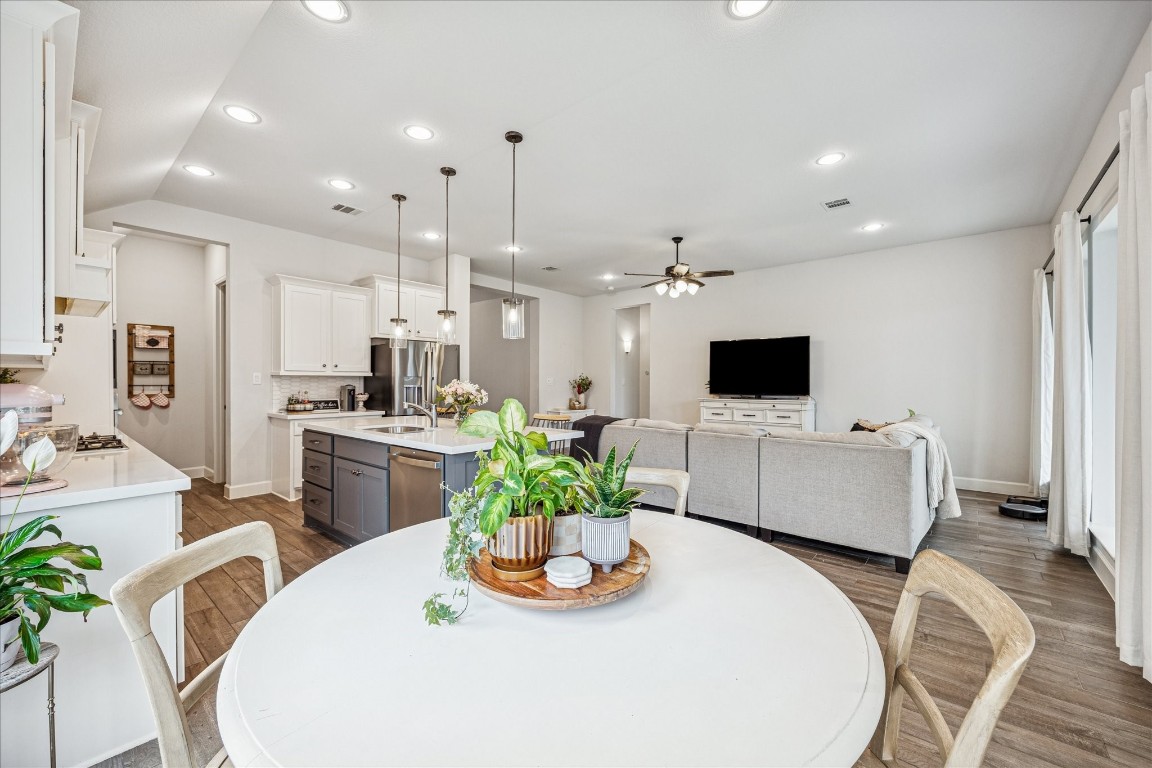4527 Peloton Road Rosharon, TX 77583 - Photo 15 of 30 a kitchen with stainless steel appliances kitchen island granite countertop a refrigerator a stove a sink a dining table and chairs with wooden floor