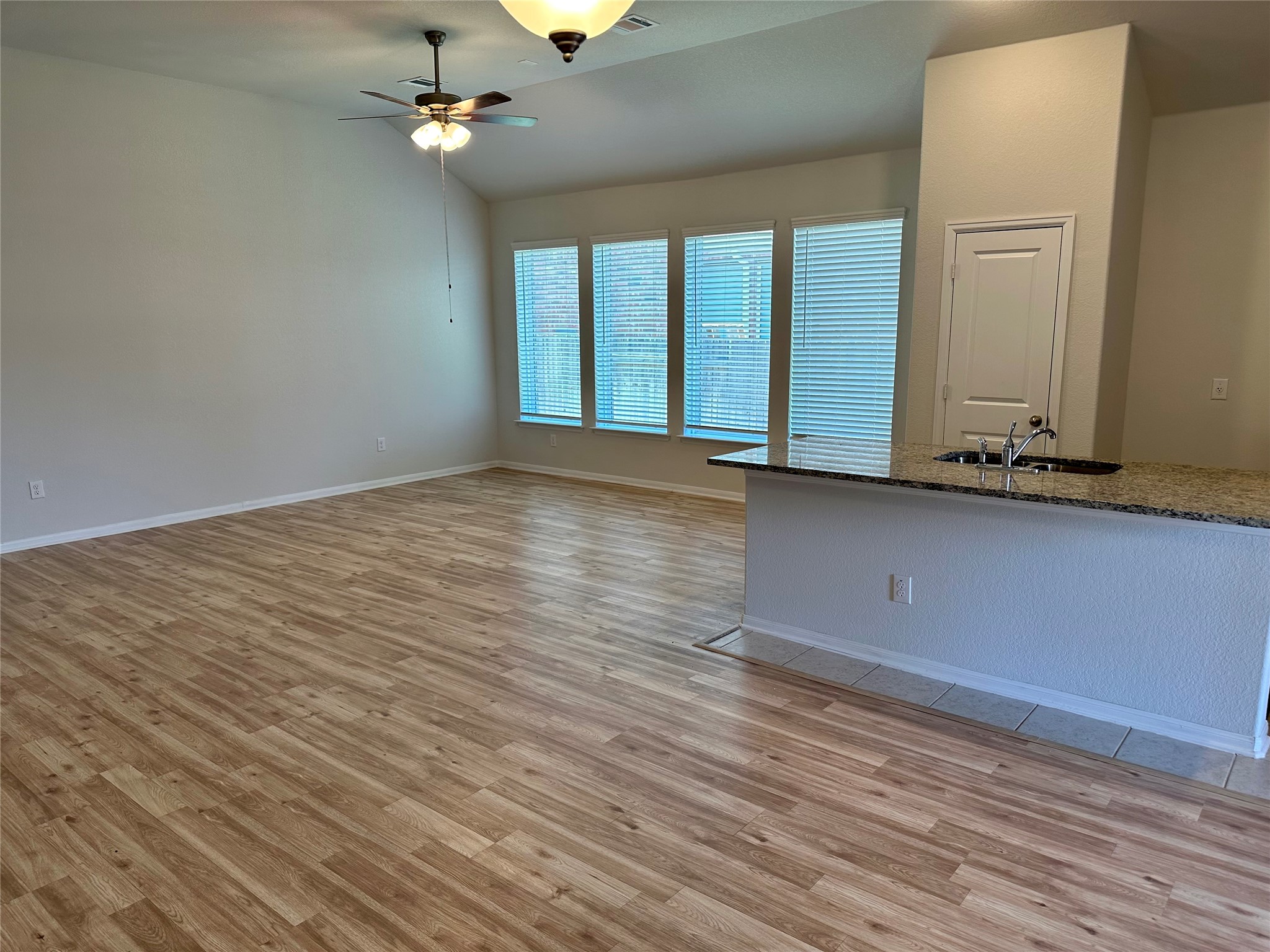 1003 Cherrystone Loop Buda, TX 78610 - Photo 8 of 27 an empty room with wooden floor chandelier fan and windows