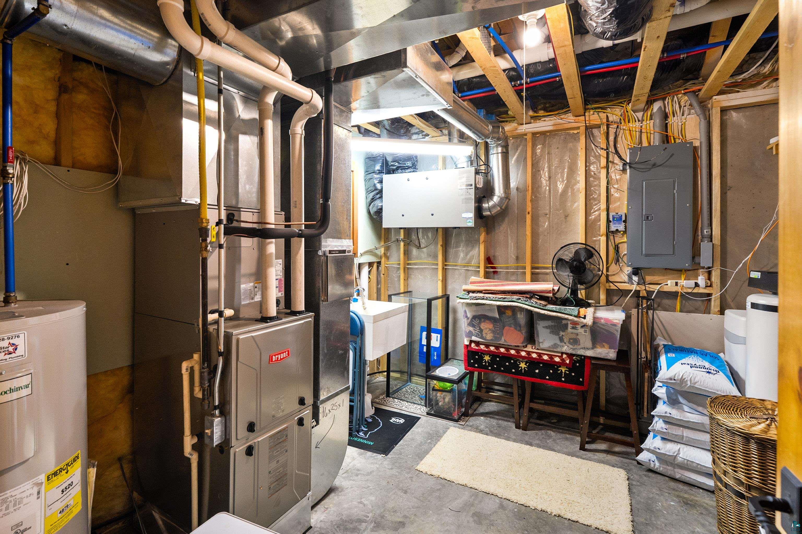 75 East Stark Road Esko, MN 55733 - Photo 48 of 87 Utility room featuring an electric water heater, Bryant furnace, exposed ceiling joists, and a utility sink