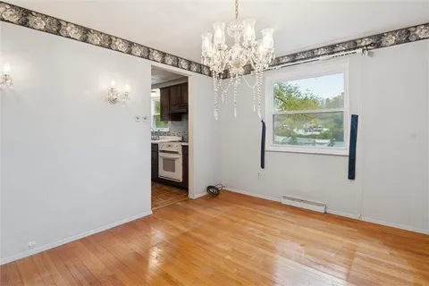 a view of a big room with windows and chandelier
