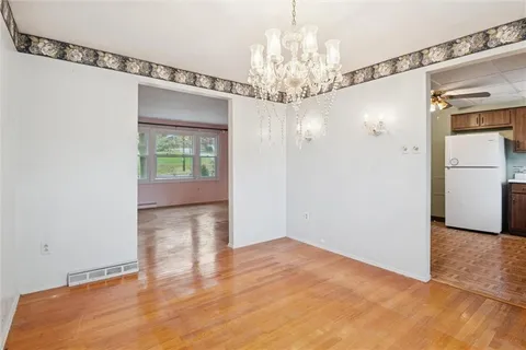 a view of a livingroom with a chandelier fan and windows