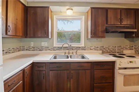 a kitchen with stainless steel appliances granite countertop a sink stove and cabinets