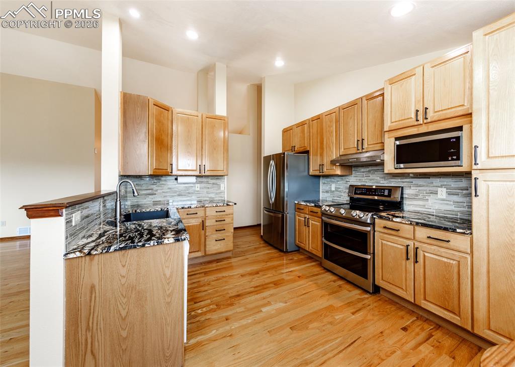 17908 New London Road Monument, CO 80132 - Photo 9 of 41 a kitchen with stainless steel appliances a stove sink microwave and cabinets
