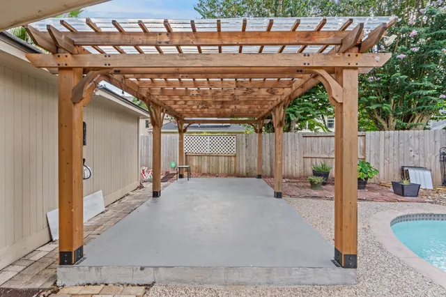 a patio with a table and chairs under an umbrella