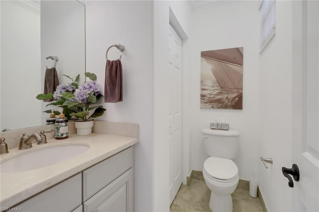 1233 Kendari Terrace Naples, FL 34113 - Photo 12 of 38 a bathroom with a toilet sink and mirror