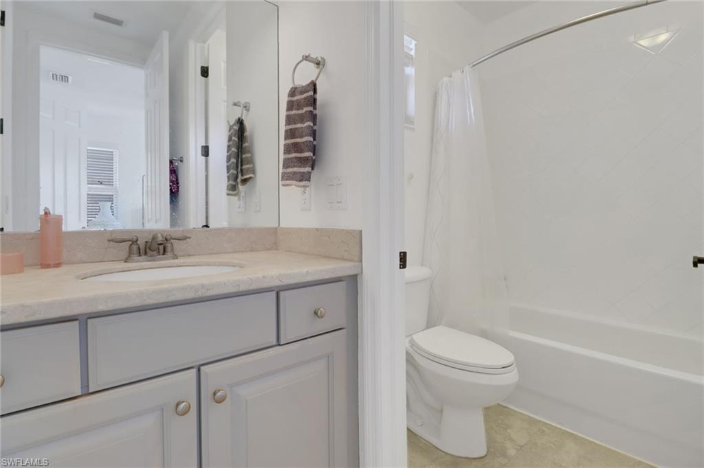 1233 Kendari Terrace Naples, FL 34113 - Photo 13 of 38 a bathroom with a granite countertop sink a toilet and shower