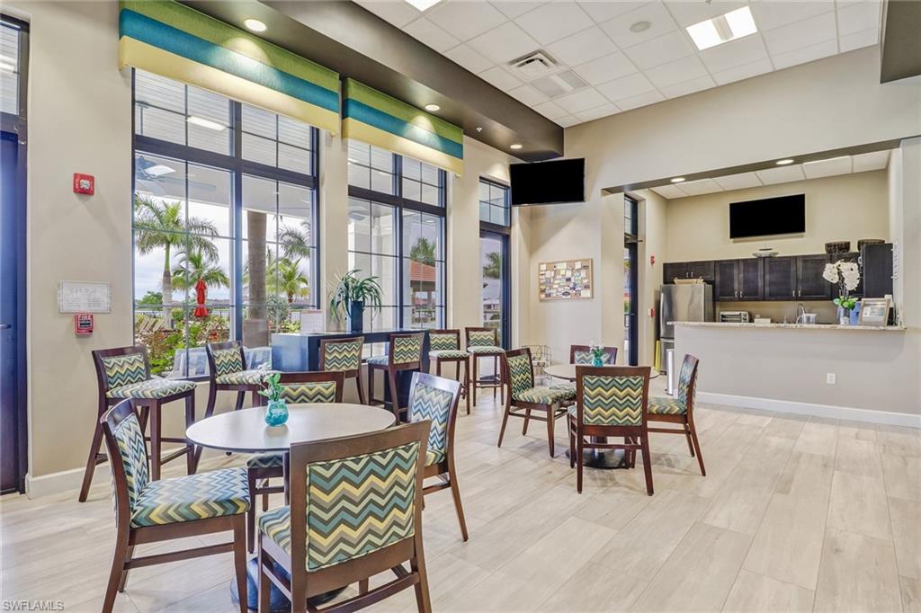 1233 Kendari Terrace Naples, FL 34113 - Photo 33 of 38 a dining room with furniture a flat screen tv and a large window