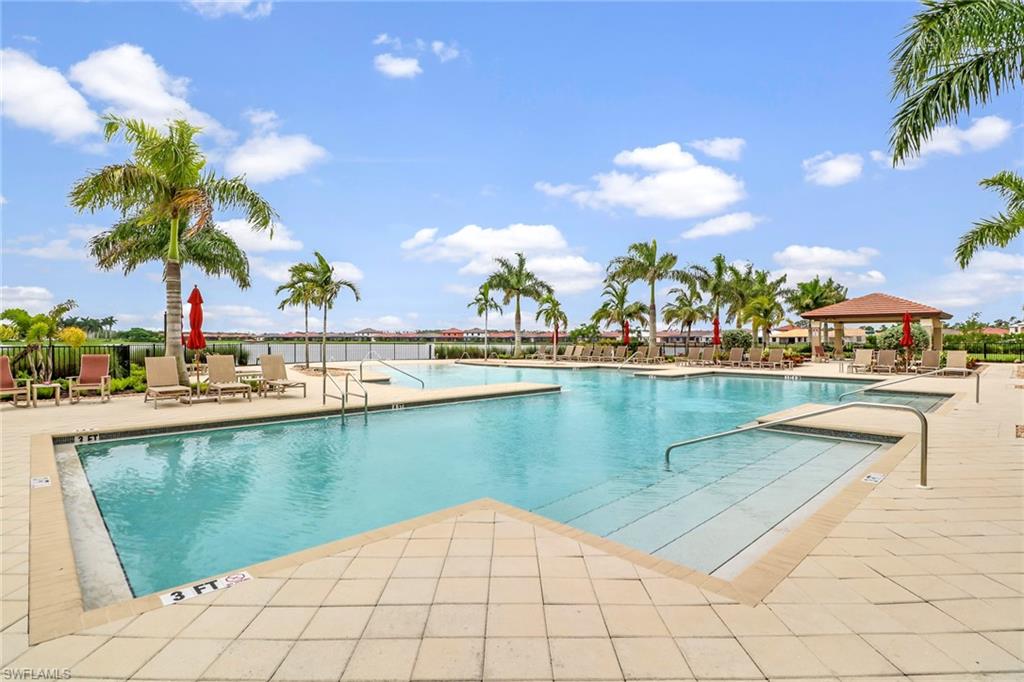 1233 Kendari Terrace Naples, FL 34113 - Photo 38 of 38 a view of a lake with a table and chairs