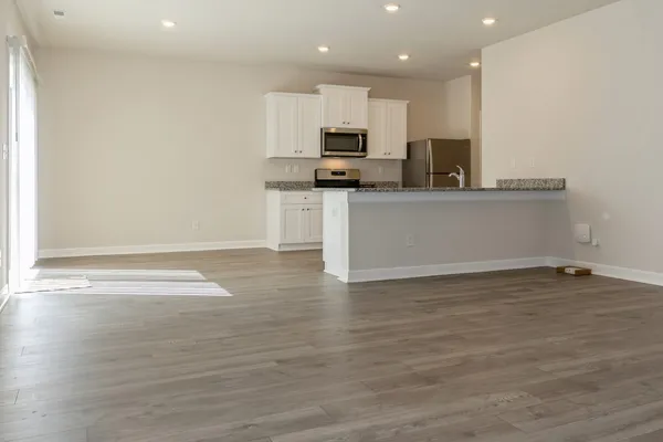 a view of kitchen with stainless steel appliances granite countertop a stove a sink and a microwave