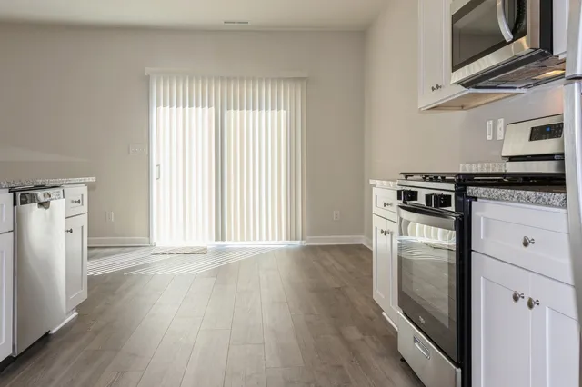 a kitchen with a stove wooden floor and a window