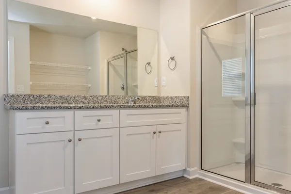 a bathroom with a granite countertop shower and a sink