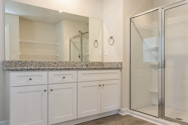 a bathroom with a granite countertop shower and a sink