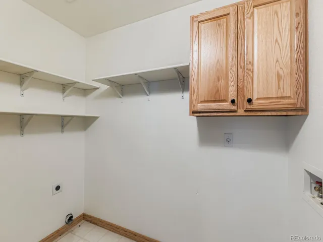 a view of cabinets and utility room with racks on the wall