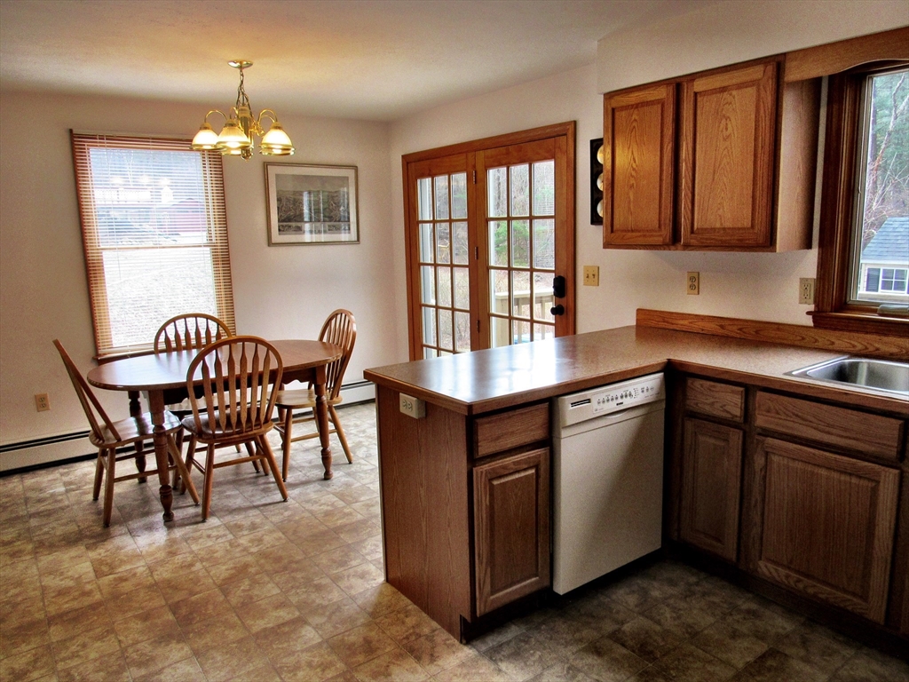 7 Beebe Road Monson, MA 01057 - Photo 11 of 30 a kitchen with granite countertop wooden cabinets dining table and stainless steel appliances