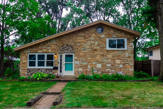 a front view of a house with a yard and green space