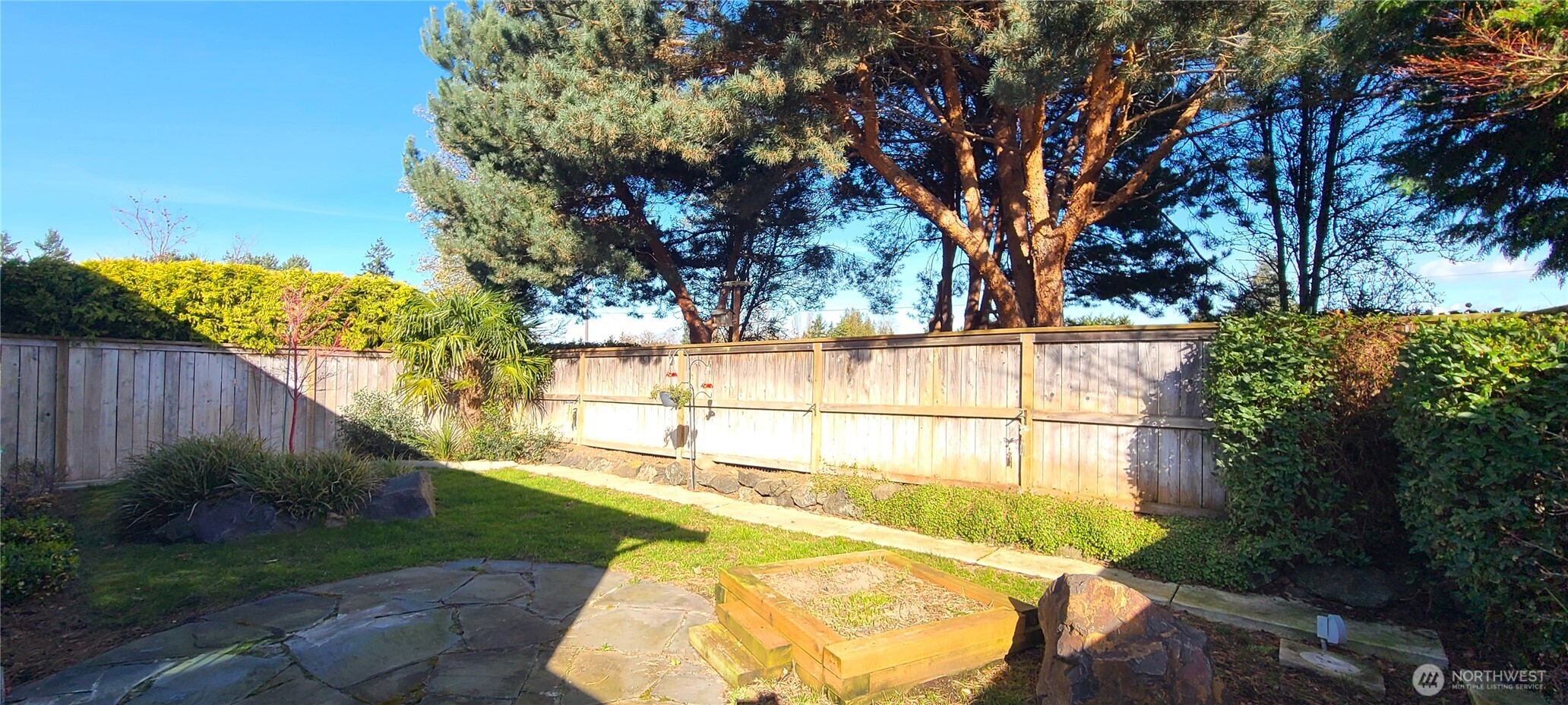 50 Goldenrod Lane Sequim, WA 98382 - Photo 4 of 24 a view of a backyard with a large tree and wooden fence