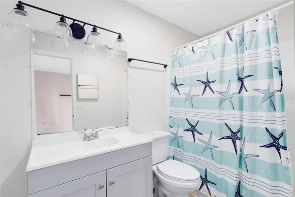 a bathroom with a sink vanity mirror and shower