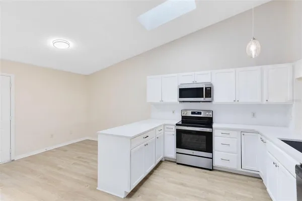 a kitchen with cabinets stainless steel appliances and sink