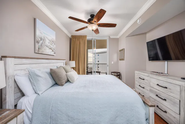 a bedroom with a large bed and a flat tv screen on dresser