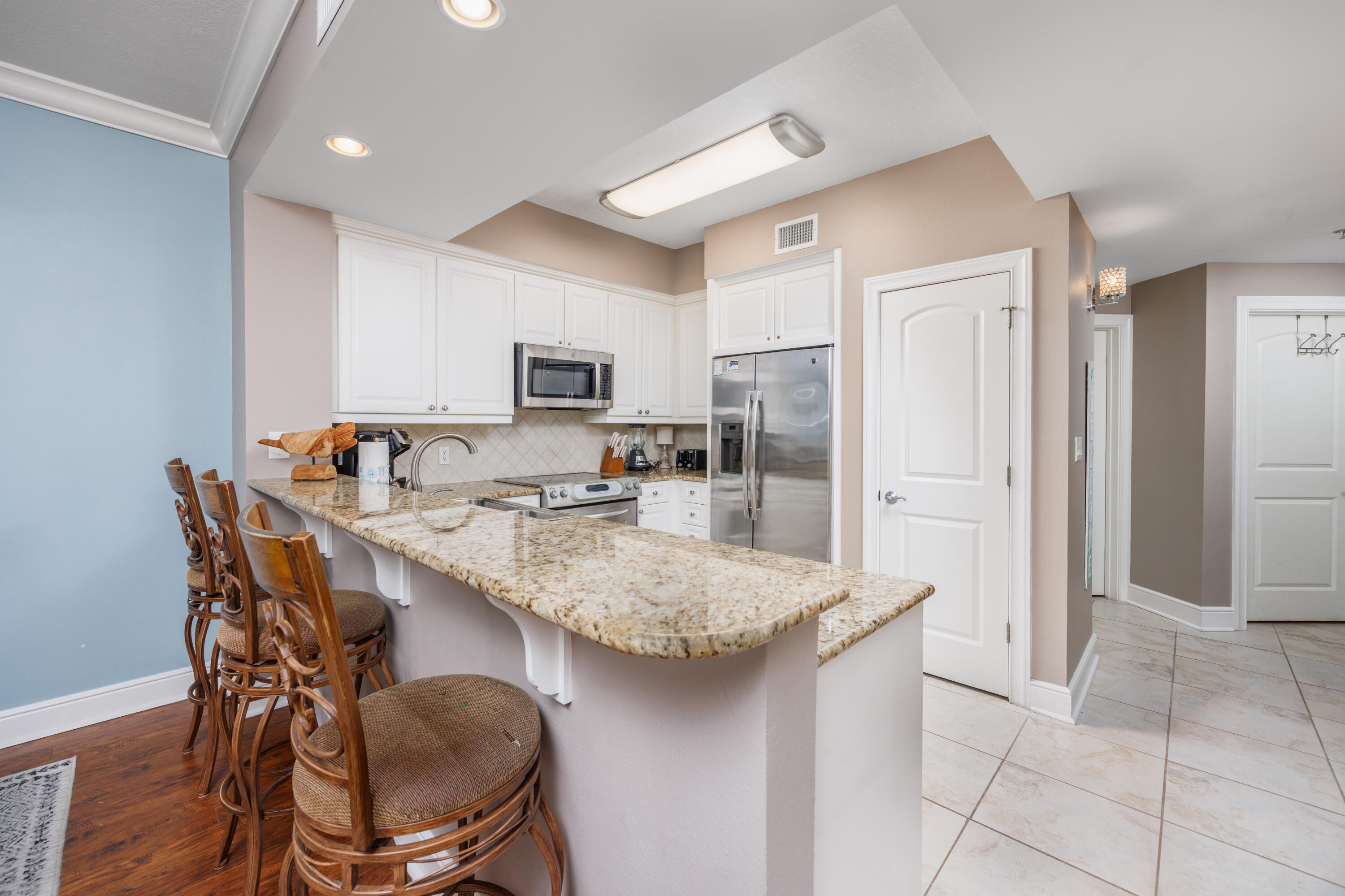 1150 Santa Rosa Boulevard, Unit 421 Fort Walton Beach, FL 32548 - Photo 7 of 46 a kitchen with stainless steel appliances granite countertop a table chairs sink refrigerator and microwave