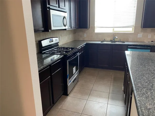 a kitchen with stainless steel appliances granite countertop a stove and a sink