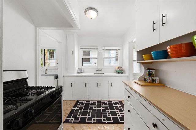 a kitchen with a sink a stove and cabinets
