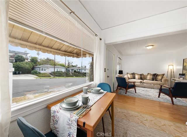 a dining room with furniture and a floor to ceiling window