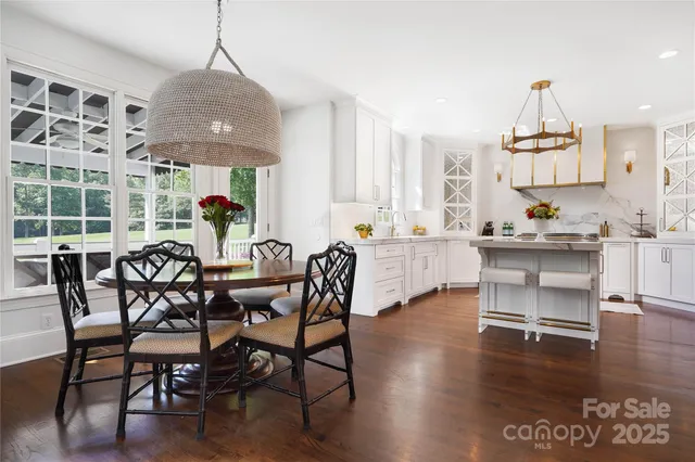 a dining room with furniture a chandelier and wooden floor