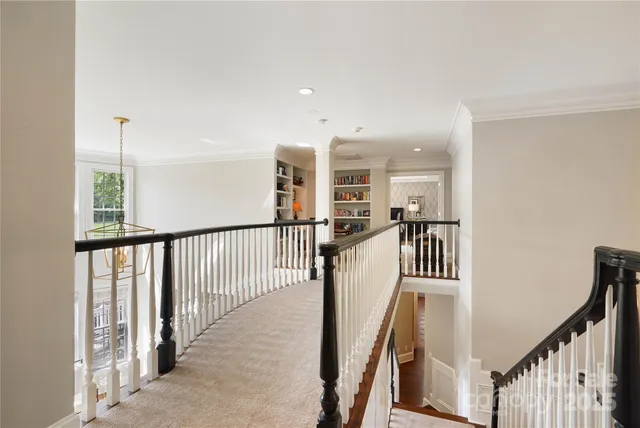 a view of a hallway with wooden floor and stairs