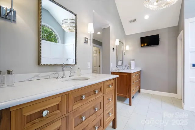 a bathroom with a double vanity sink a mirror and a bathtub
