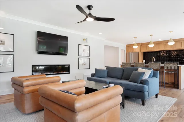 a living room with furniture a flat screen tv and a fireplace