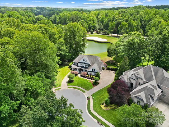 an aerial view of a house with a yard lake swimming pool patio and outdoor seating