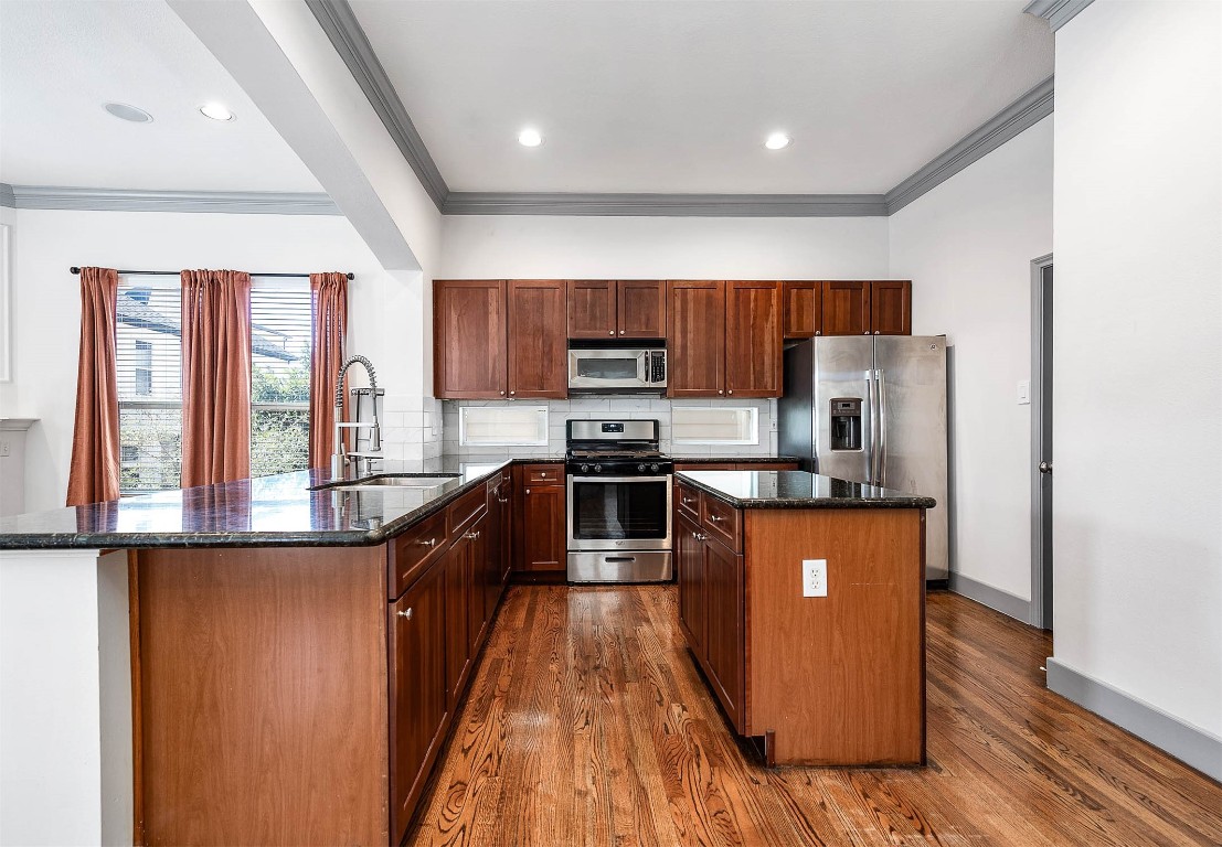 5723 Petty Street Houston, TX 77007 - Photo 12 of 31 a kitchen with stainless steel appliances granite countertop a stove a sink and a refrigerator
