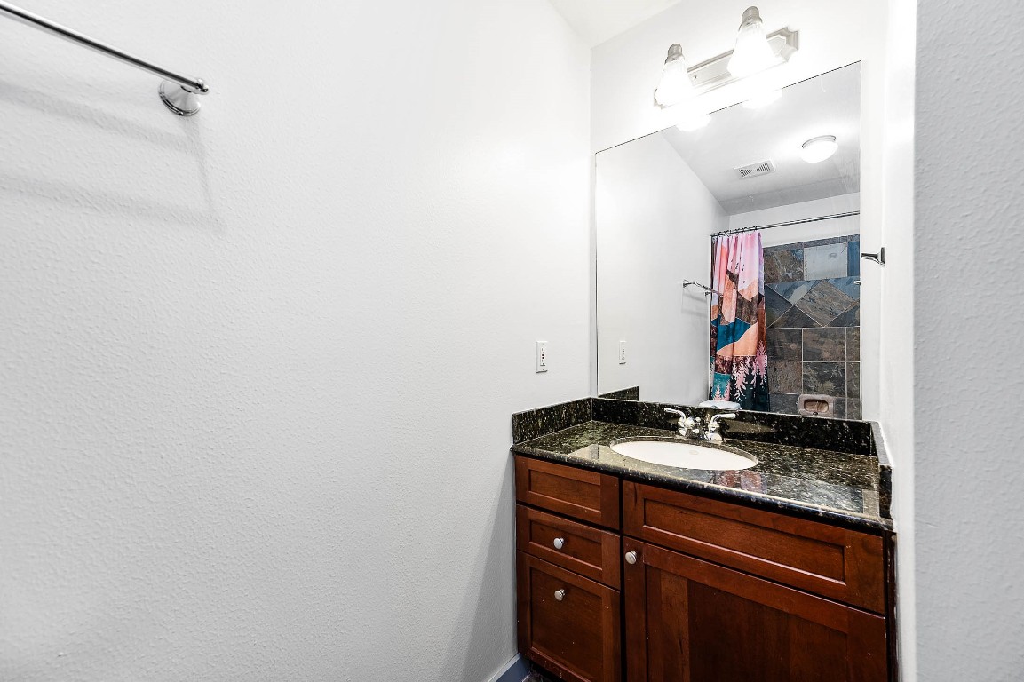 5723 Petty Street Houston, TX 77007 - Photo 7 of 31 a bathroom with a granite countertop sink and a mirror