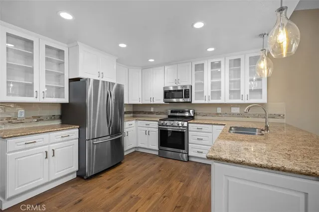 a large kitchen with stainless steel appliances granite countertop a stove and a refrigerator