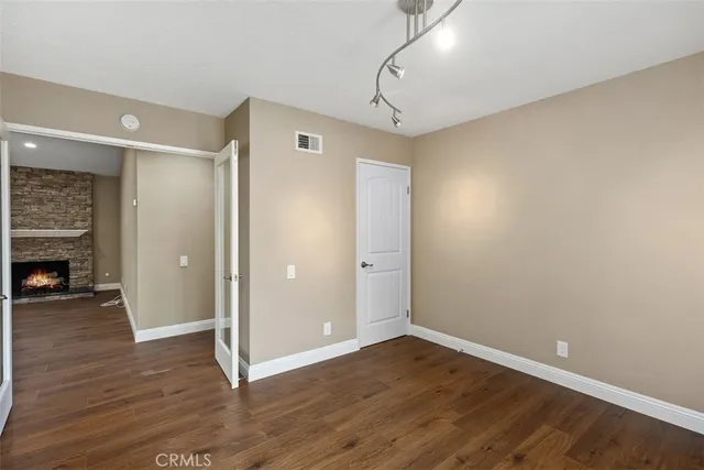 a view of empty room with wooden floor and fireplace