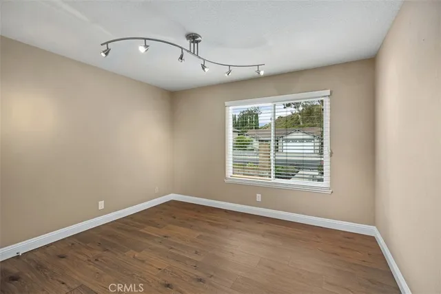 an empty room with wooden floor and a fireplace