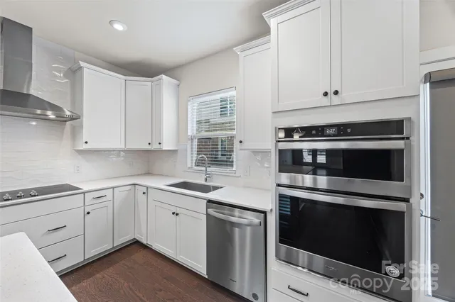 a kitchen with cabinets stainless steel appliances and sink
