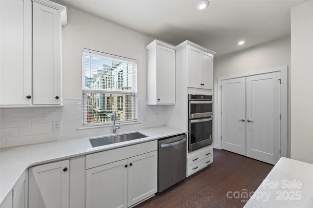 a kitchen with white cabinets and window