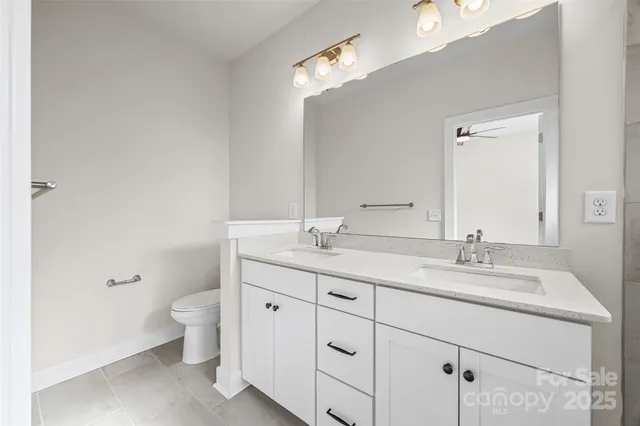 a bathroom with a granite countertop sink a toilet and a mirror