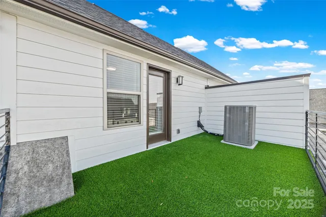 a view of a backyard with potted plants and a large tree