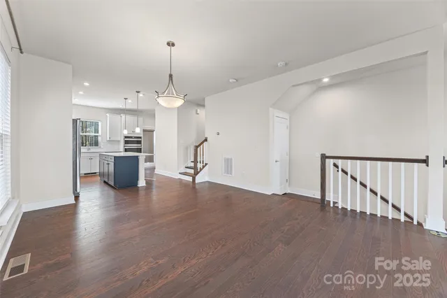 a view of a room with wooden floor and kitchen