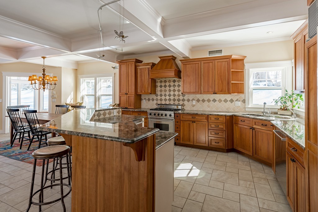 27 Old England Road Ipswich, MA 01938 - Photo 6 of 22 a kitchen with a stove a sink a dining table and chairs