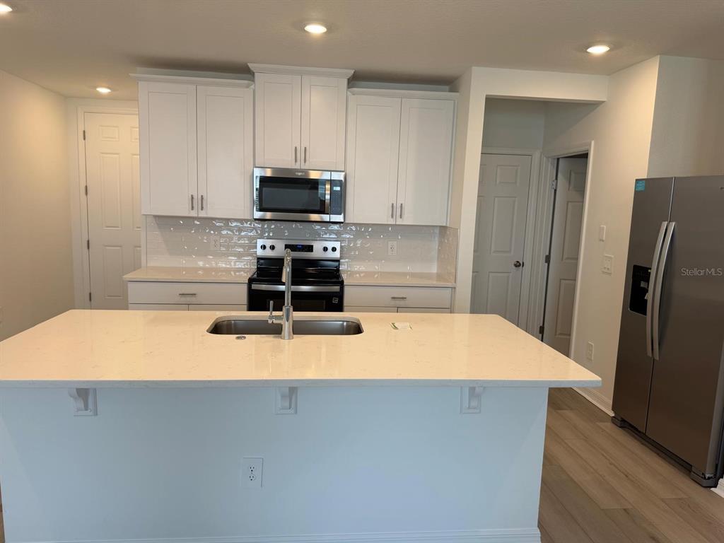 4264 Ranch House Road St. Cloud, FL 34772 - Photo 3 of 34 a kitchen with stainless steel appliances a refrigerator sink and stove